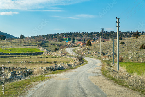 Winding asphalt road leading to the hilltop village