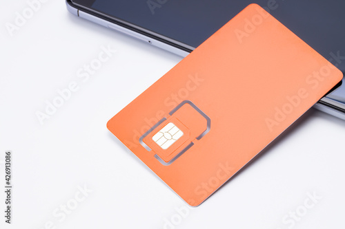 sim card for mobile phone near smartphone on white background. LTE sim card for cell phone