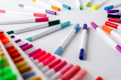 Lots of colorful markers set up on white background