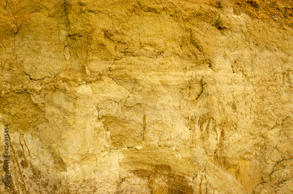 Natural background - vertical wall of sand in sand pit.