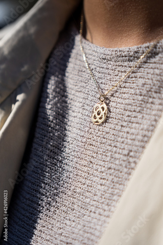 Girl wearing a pendant with the Barcelona symbol. Woman with necklace with the flower of Barcelona.