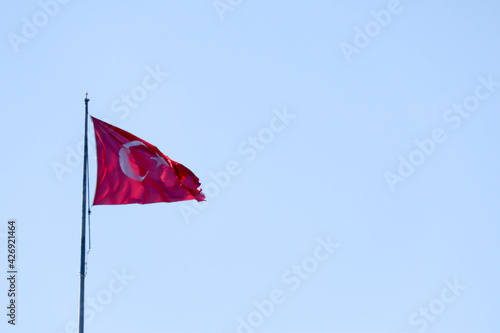 the turkish flag waving in the wind against the blue sky