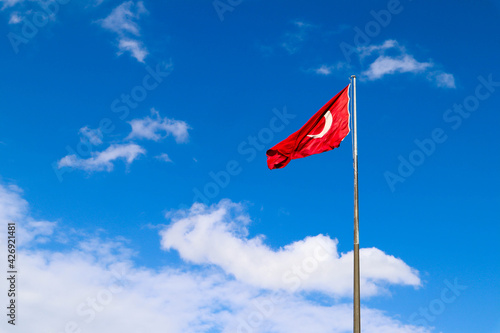 the turkish flag waving in the wind against the blue sky