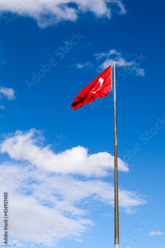 the turkish flag waving in the wind against the blue sky