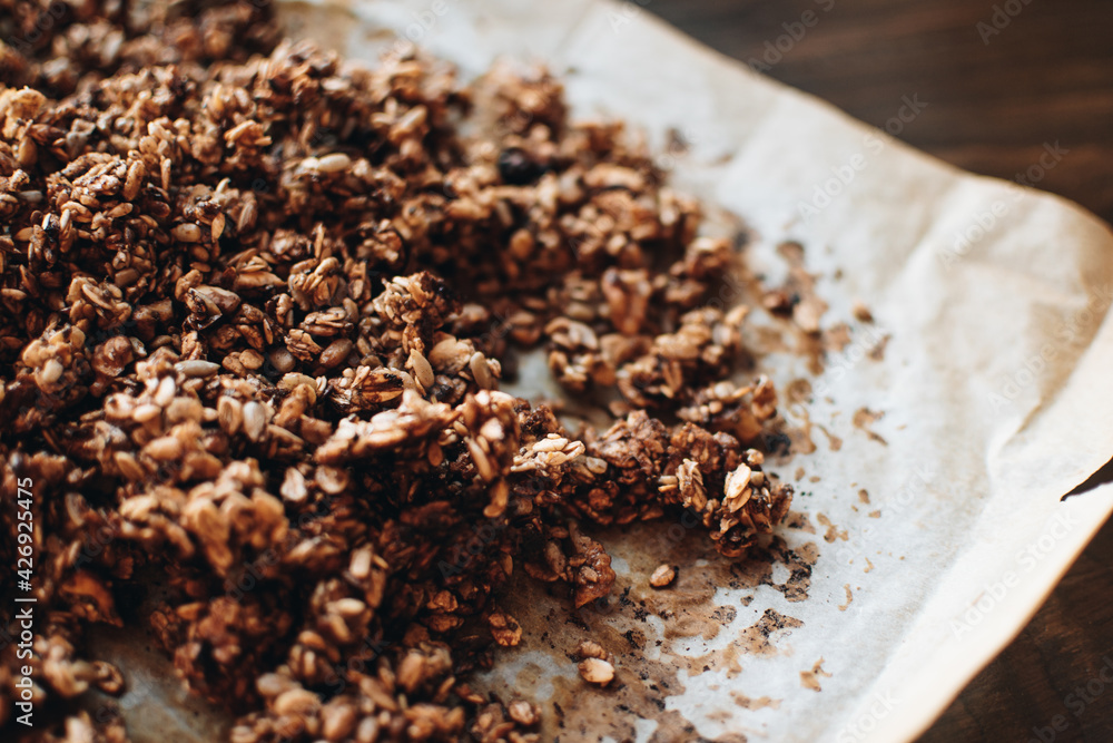 Homemade granola with nuts and seeds on baking sheet with ingredients. Granola for healthy breakfast. Homemade granola with nuts and seeds on baking sheet with ingredients. Granola for healthy breakfast.