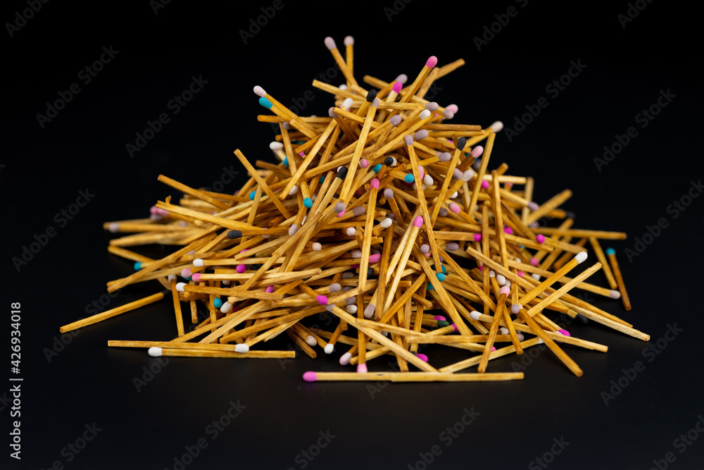 a lot of matches are lying on a black background. selective focus