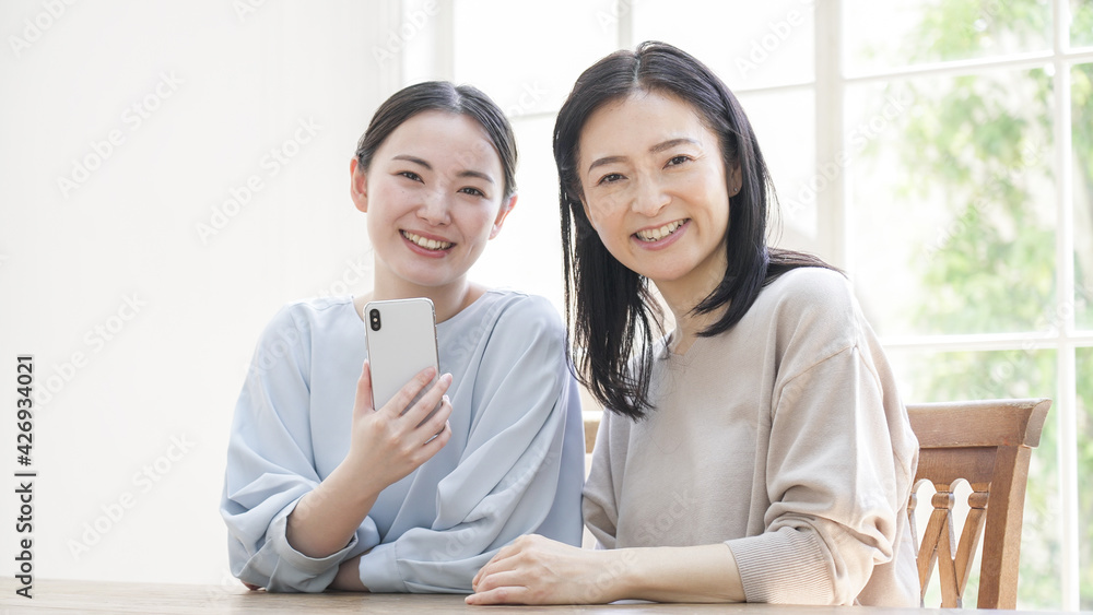 Fototapeta premium 一緒にスマホを見る二人の女性