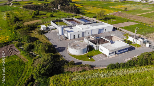 Aerial view of wastewater treatment plant, filtration of dirty or sewage water in Esposende, Portugal. Modern plant building and trickling filters for waste-water treatment.