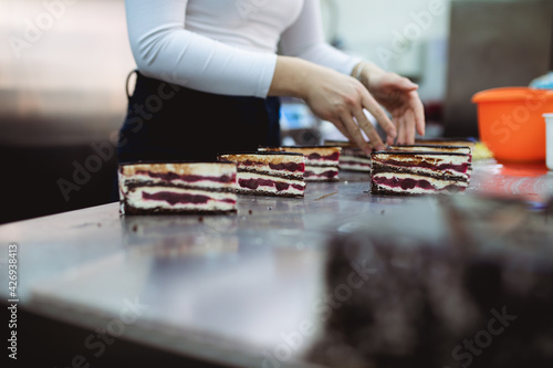 A professional confectioner makes and decorates delicious cakes.