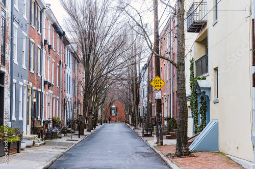 Rows of brownstone apartment buildings in Center City with windows, stoops and plant bushes in Pennsylvania photo