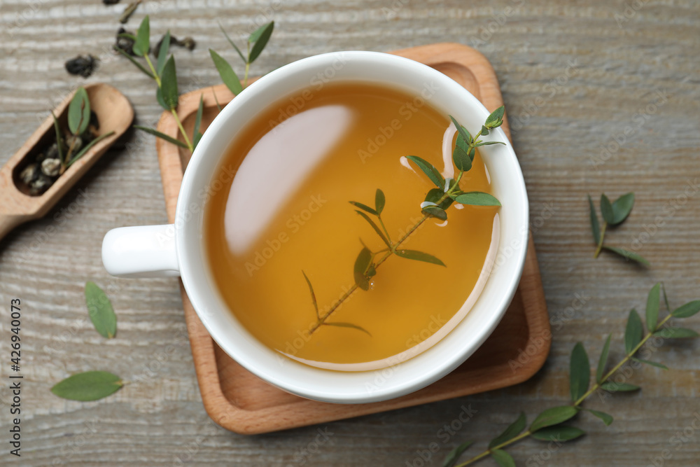 Cup of aromatic eucalyptus tea on wooden table, flat lay Cup of aromatic eucalyptus tea on wooden table, flat lay