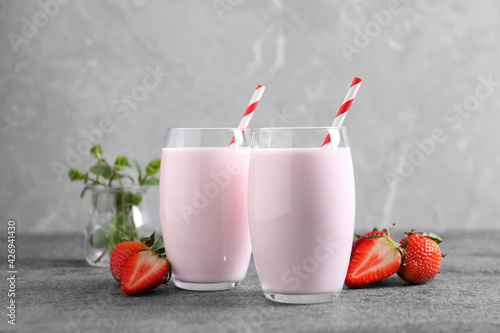 Delicious drink with strawberries on grey table