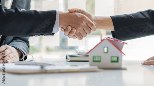 Real estate agents and clients shake hands after the deal is done on the home purchase and rental concept.