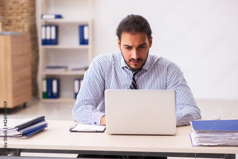 Young male employee working in the office Young male employee working in the office