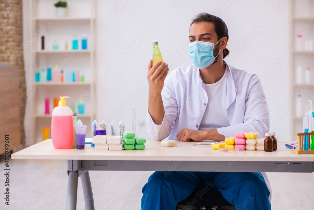 Young male chemist testing soap in the lab Young male chemist testing soap in the lab