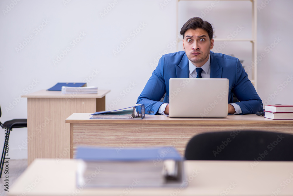 Young male employee being unhappy with excessive work Young male employee being unhappy with excessive work