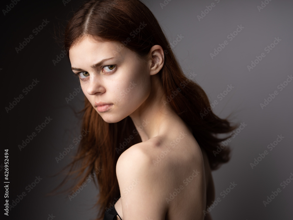 Side view of red-haired lady portrait on gray background beautiful face Side view of red-haired lady portrait on gray background beautiful face
