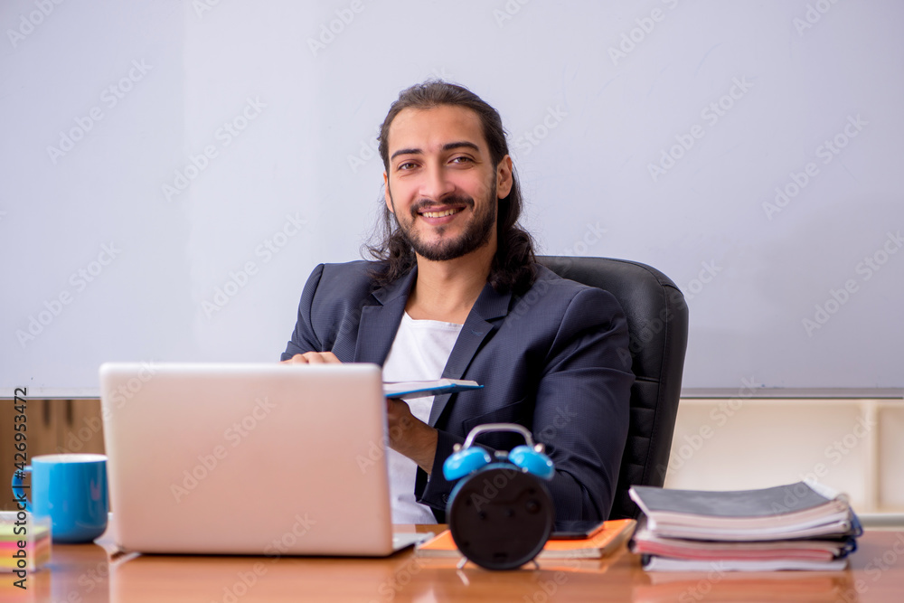 Young male teacher in the classroom Young male teacher in the classroom