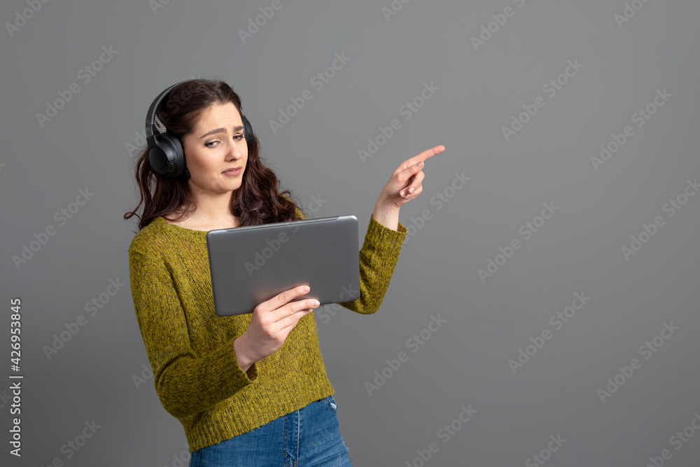 young woman with headset and tablet in hand playing games and talking to friends online young woman with headset and tablet in hand playing games and talking to friends online