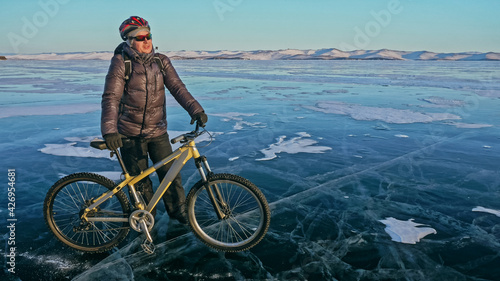 Man is riding bicycle on the ice. Ice of frozen Lake Baikal. Rid