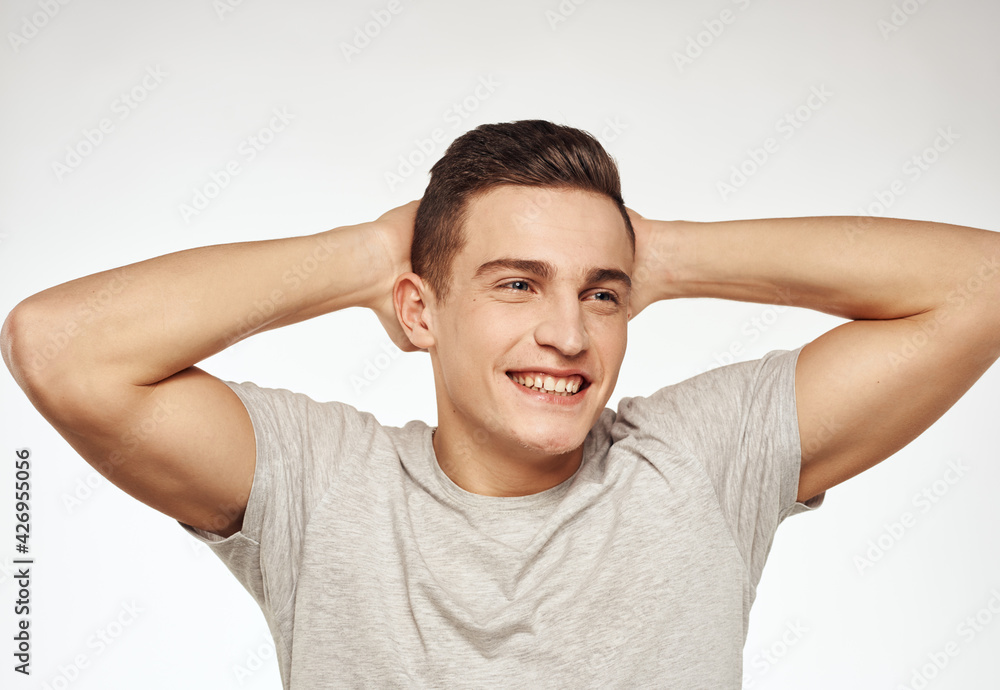 Cheerful man gesturing with his hands on a gray Studio T-shirt Cheerful man gesturing with his hands on a gray Studio T-shirt