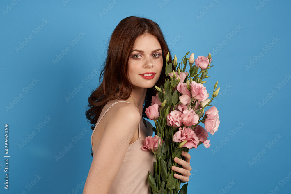 Fototapeta premium pretty woman with bouquets of flowers holiday womens day glamor blue background