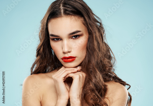 Charming lady red lips brunette blue background makeup model
