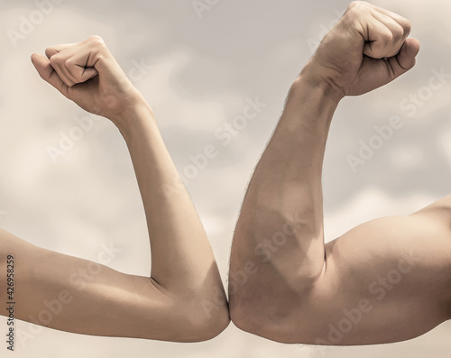 Muscular arm vs weak hand. Vs  fight hard. Competition  strength comparison. Rivalry concept. Hand  man arm fist Close-up. Rivalry  vs  challenge  strength comparison. Sporty man and woman