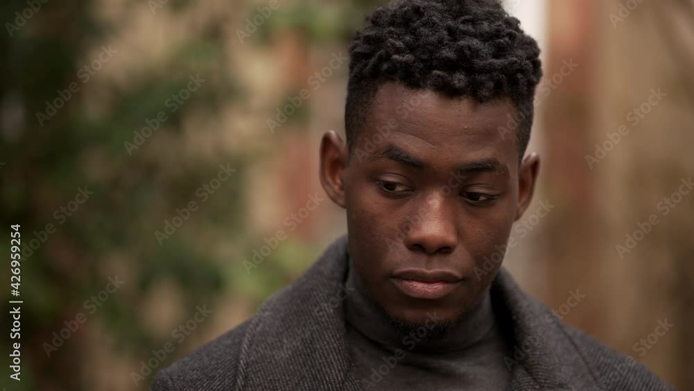 Young black man standing outdoors, close-up face handsome African male Young black man standing outdoors, close-up face handsome African male