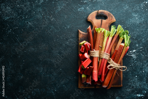 Fotografía Chopped fresh rhubarb on a black stone background