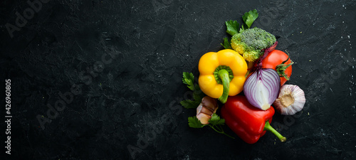Ripe vegetables. Fresh vegetables on black stone background. Tropical fruits. Top view. Free space for your text.