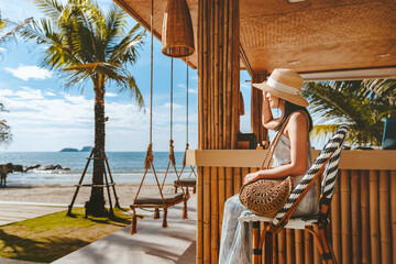 Traveler asian woman travel and relax on swing in beach cafe at Koh chang summer Thailand