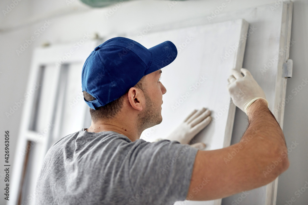 Young adult man working on a DIY budget renovation of his new home apartment. Young adult man working on a DIY budget renovation of his new home apartment.