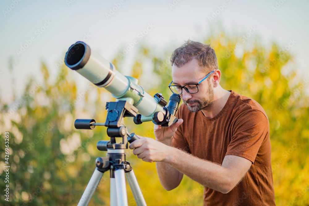 Amateur astronomer looking at the sky with a telescope.