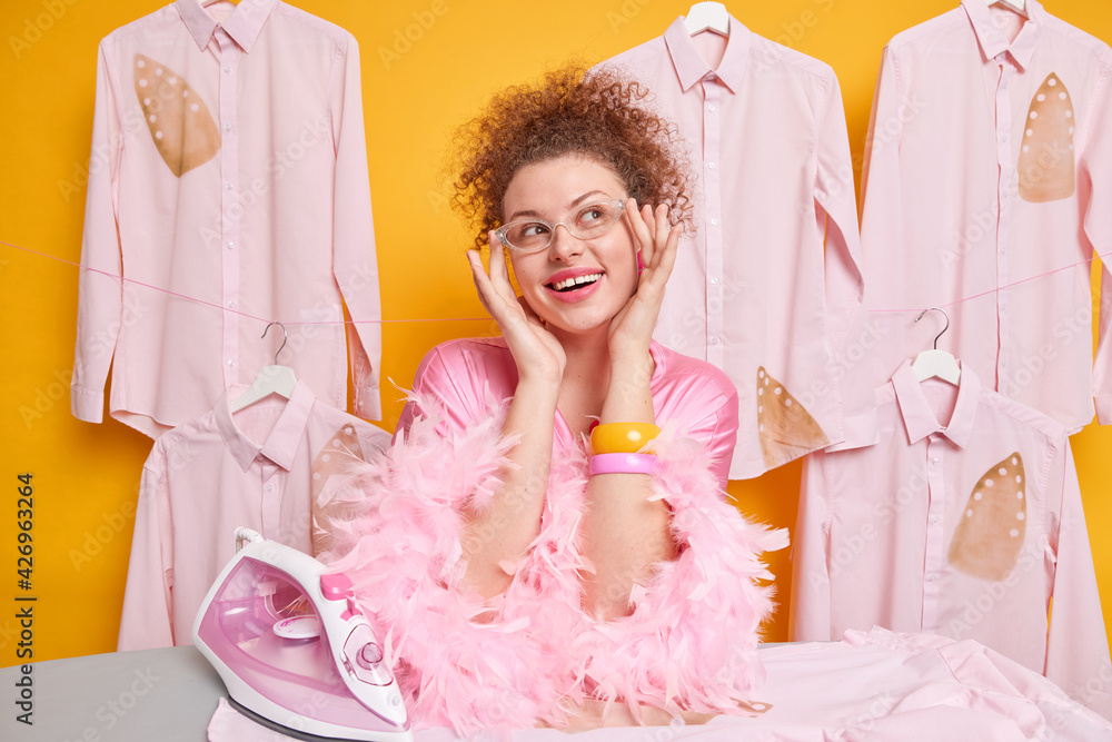 domestic-work-and-housekeeping-concept-pleased-dreamy-woman-with-curly