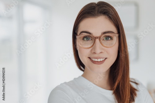 Happy friendly attentive young woman with lovely blue-grey eyes
