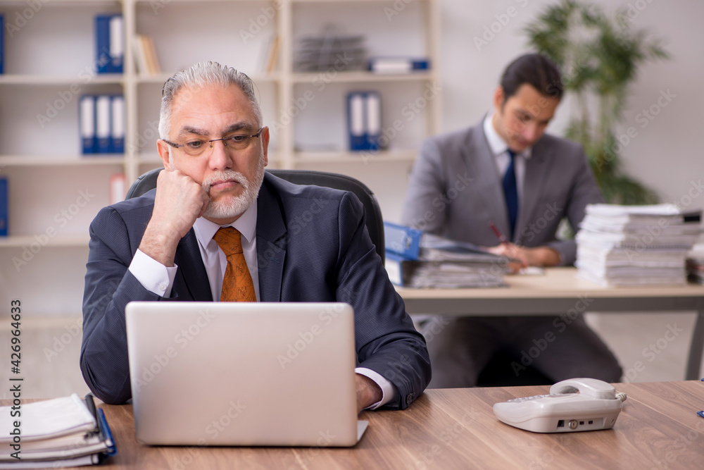 Two employees sitting at workplace Two employees sitting at workplace