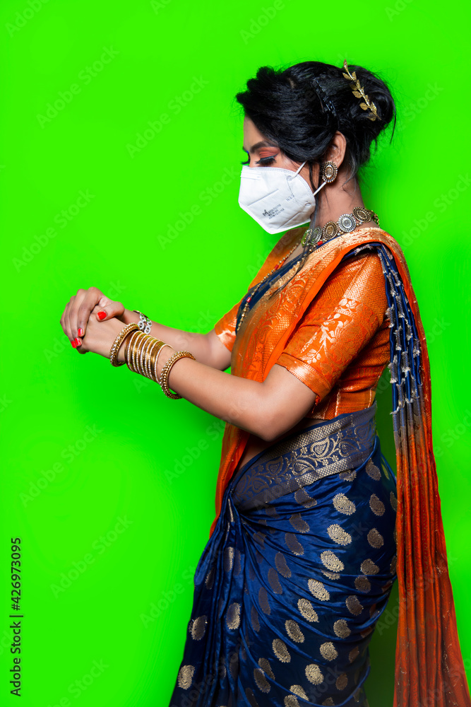 Traditional Indian woman in saree wearing a white face mask, Mask is mandatory due to corona