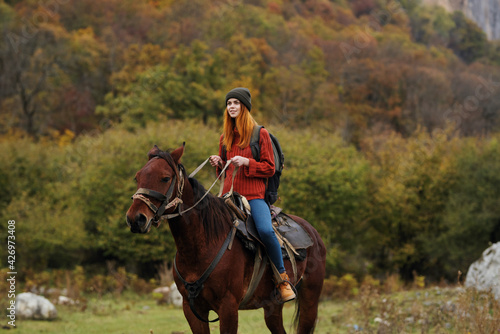 woman riding a horse on nature mountains travel adventure