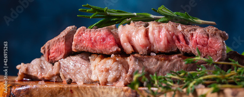 cooked medium-rare beef steak close-up, with rosemary on a background with vegetables. Meat Recipes, Recipe Book, Selling Meat in Market or Store on Banner