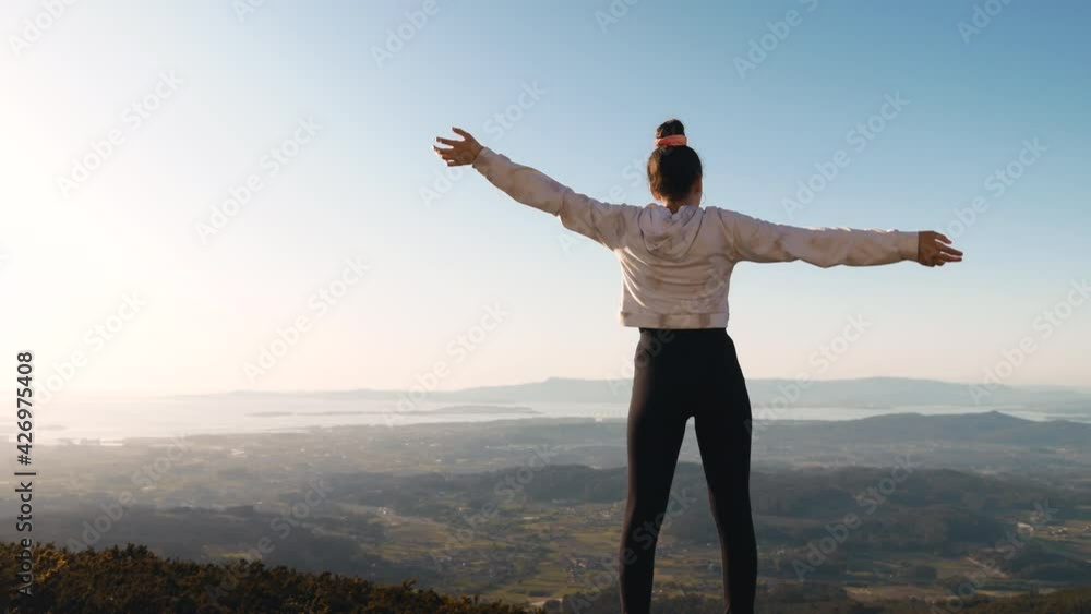 This video shows a teenage girl on the top of a hill, her arms outstretched, natural landscape on the background. This video shows a teenage girl on the top of a hill, her arms outstretched, natural landscape on the background.
