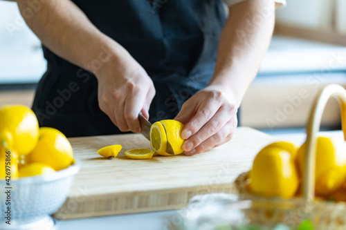 Woman cutting lemons in kitchen.