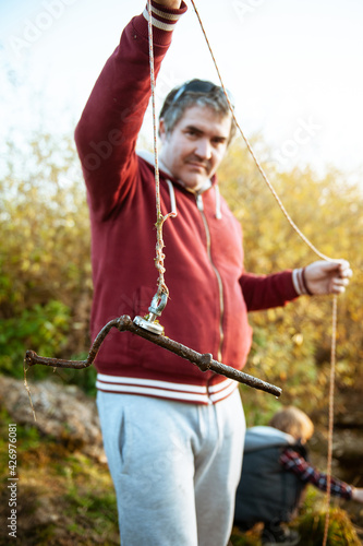 Portrait of a man with a search magnet. His hobby is magnetic fishing.