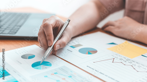 Businessmen working in the office using the expense and budget accounting calculator with graphs as a measure of the company's growth, financial and accounting concepts.