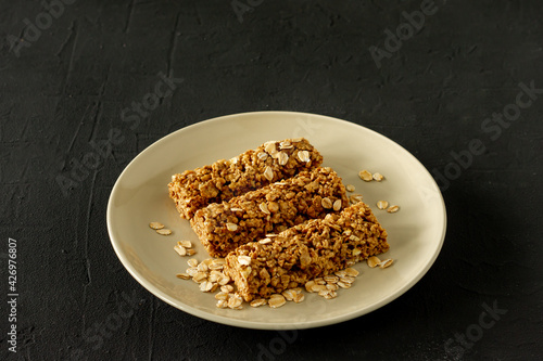 homemade granola energy bars with almond and raisins on black background. Healthy food