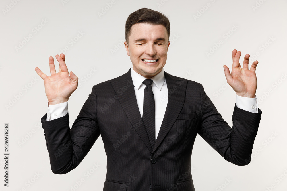 Young employee business corporate lawyer man in classic formal black grey suit shirt tie work in office wait special moment keep finger cross make wish eyes closed isolated on white background studio Young employee business corporate lawyer man in classic formal black grey suit shirt tie work in office wait special moment keep finger cross make wish eyes closed isolated on white background studio