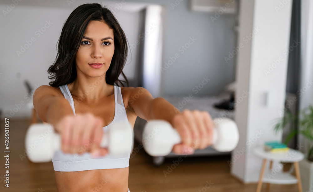 Fit sports woman exercising and training at home
