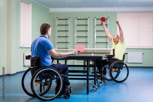 Adult disabled men in a wheelchair playing table tennis © romaset
