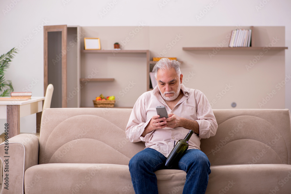 Old man drinking alcohol at home Old man drinking alcohol at home