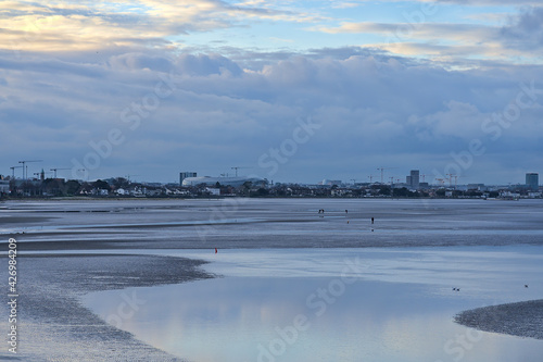 Beautiful evening view of Blackrock Beach during low tide with Aviva Stadium and lots of construction cranes in background, Dublin Ireland